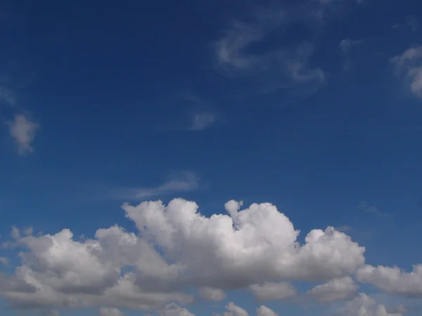 Nubes esponjosas blancas en el cielo azul — Foto de Stock