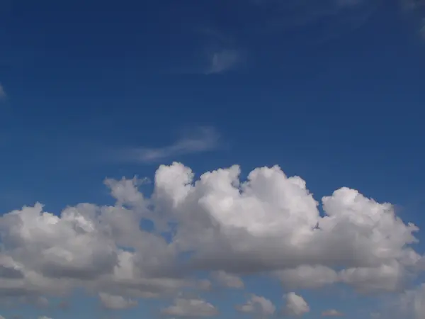 Nuvens brancas fofas no céu azul — Fotografia de Stock