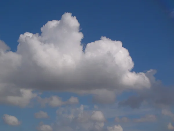Witte pluizige wolken in de blauwe lucht — Stockfoto