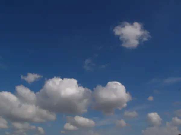 Weiße, flauschige Wolken am blauen Himmel — Stockfoto