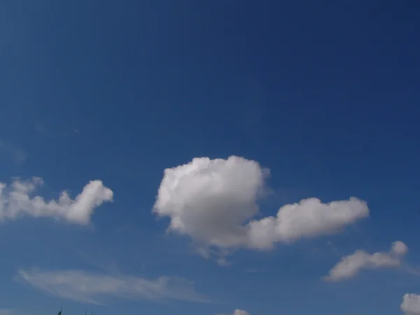 Білі пухнасті хмари на блакитному небі — стокове фото