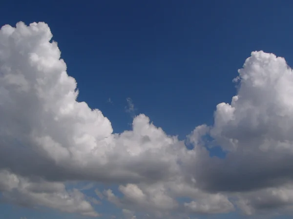 Weiße, flauschige Wolken am blauen Himmel — Stockfoto