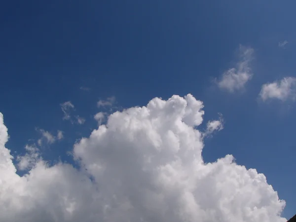 Nubes esponjosas blancas en el cielo azul — Foto de Stock