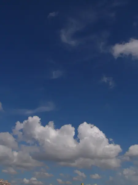 Weiße, flauschige Wolken am blauen Himmel — Stockfoto