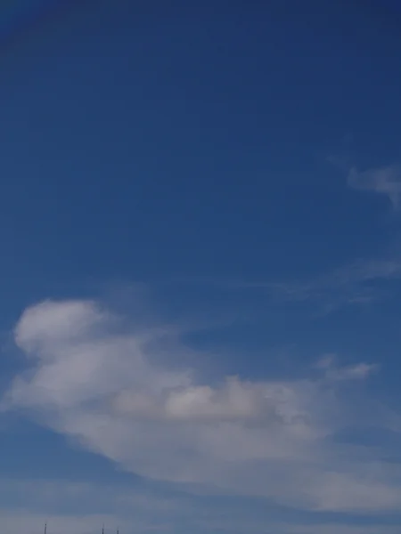 Nuvens brancas fofas no céu azul — Fotografia de Stock