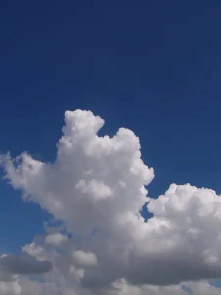 Weiße, flauschige Wolken am blauen Himmel — Stockfoto