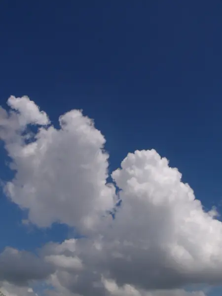 Weiße, flauschige Wolken am blauen Himmel — Stockfoto