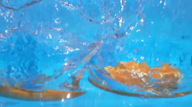 Portakal dilimleri suya düşer.