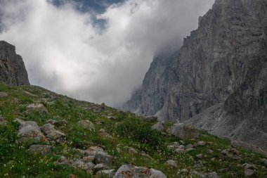 Bulutlar kayalık dağlara indi.