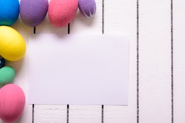 Renkli ekolojik strafor Paskalya yumurtaları ve ahşap arka plan beyaz sayfa boş