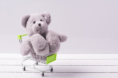 Küçük alışveriş sepeti ve bir oyuncak ayı. Oyuncak ya da çocuk fantezileri Satılık kavramsal görüntü