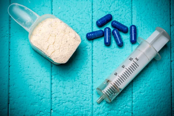 우유 유 장 단백질, 빈 주사와 알 약의 컨테이너. 클로즈업입니다. 파란색 배경 — 스톡 사진