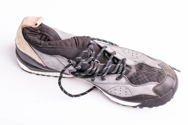 Zapatos de entrenamiento usados viejos con corbatas sobre un fondo blanco — Foto de Stock