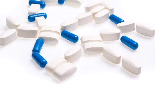 Wit en blauw medische pillen voor de behandeling van ziekten op een witte achtergrond — Stockfoto