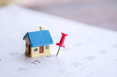 ev modeli ve takvimdeki kırmızı iğne izi, ev ödemesi için son gün, mülk anımsatma kavramı