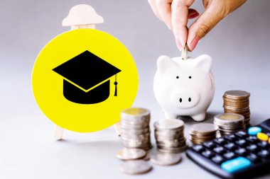 Mezuniyet şapkası ve kumbarada tasarruf parası, yatırım eğitimi konsepti.