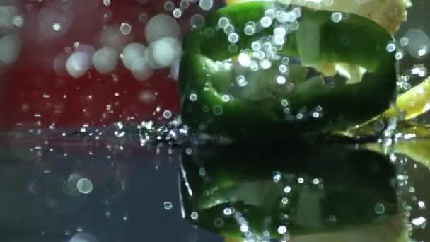 Ardei gras care cade pe suprafața apei — Videoclip de stoc