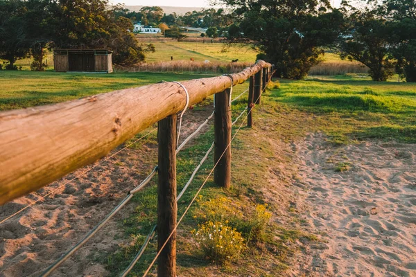 farm fence and sandy path in a rural setting at sunset