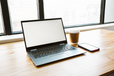 Boş ekran, kahve ve ahşap bir masada akıllı telefon olan bir bilgisayar.