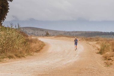 Kırk küsur koşucu toprak bir yolda koşuyor.