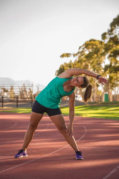 Kadın atlet bir koşu parkuru germe — Stok fotoğraf