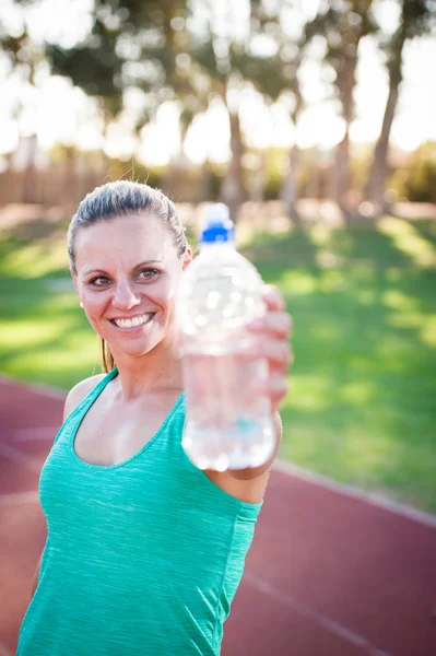 Жінка-спортсменка тримає пляшку води — стокове фото