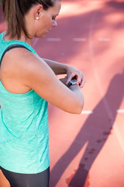 Close up image of a female athlete adjusting her heart rate moni — Stock Photo, Image