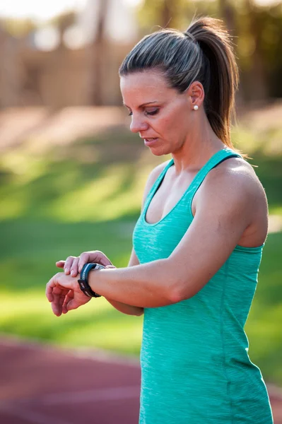 Imagem de uma atleta feminina ajustando seu monitor de frequência cardíaca — Fotografia de Stock