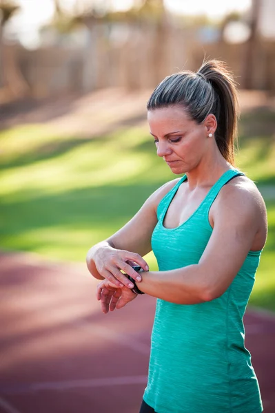 Imagen de una atleta ajustando su monitor de frecuencia cardíaca —  Fotos de Stock