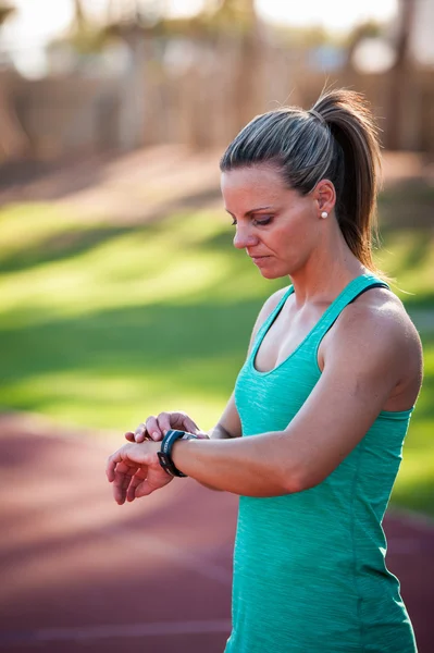 Imagen de una atleta ajustando su monitor de frecuencia cardíaca —  Fotos de Stock