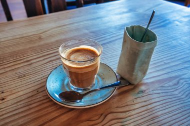 Dikey yakın plan: bir bardak kahve, şeker torbası, bulanık arkaplan