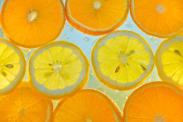 Rebanadas de fruta en agua con burbujas — Foto de Stock