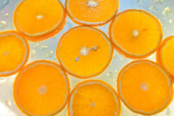 Fondo de naranjas en agua con burbujas — Foto de Stock