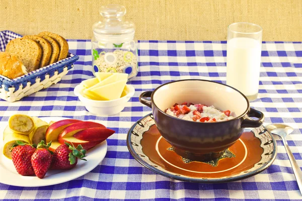Still life breakfast of oat porridge with strawberries on a chec Stock Picture
