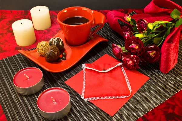 Café en tasse rouge avec enveloppe cadeau — Photo