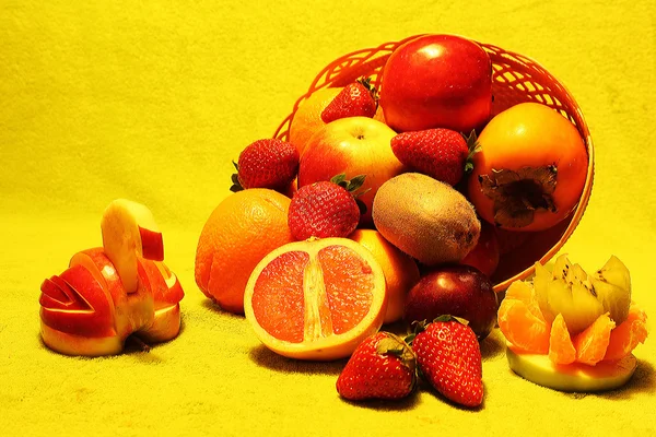 Fruit in een mandje op een gele achtergrond — Stockfoto