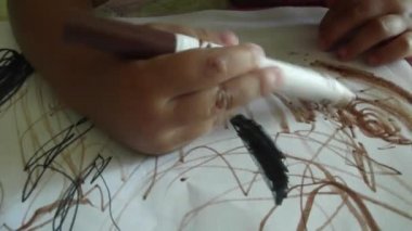 Küçük çocuk bir marker kalem kağıt üzerinde çizer. çocuğun el kahverengi keçeli kalem kağıt üzerinde çizer. Çizim bebek.