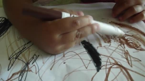 El niño pequeño dibuja un rotulador sobre papel. la mano del niño dibuja la pluma marrón de la fieltro-punta en papel. dibujo del bebé . — Vídeos de Stock