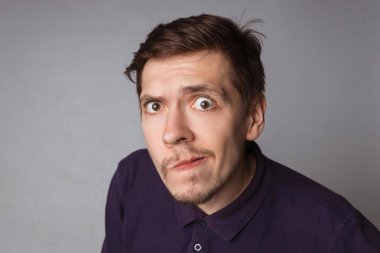 Duygular konsepti. Şok olmuş, küçük sakallı bir erkek portresi diyor ki, vay canına, böcek gözlü ve yuvarlak ağızlı görünüyor, beklenmedik bir şey görünce hayrete düşüyor. Şaşırmış suratlı, korkmuş bir adam..