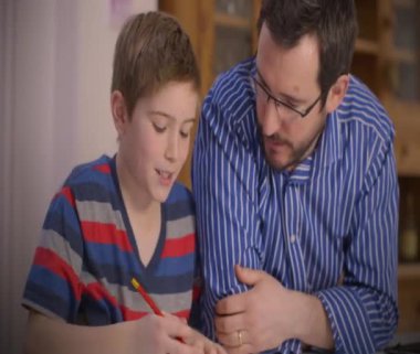 Babası küçük oğlu ev ödevlerinde yardımcı olur