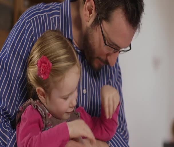 Батько читає цікаву казку своїй маленькій доньці — стокове відео