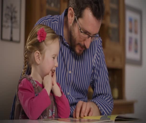 Ojciec czyta ciekawe bajki do jego córeczka — Wideo stockowe