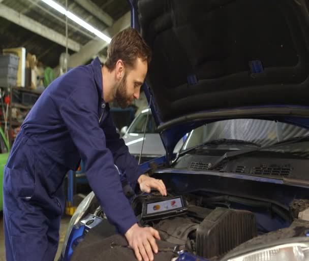 Portret van een vriendelijke mechanic met behulp van een digitale tablet — Stockvideo