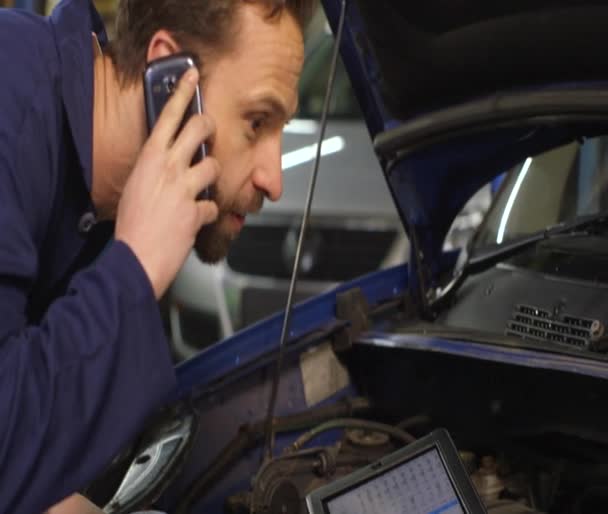 Mechaniker telefoniert mit dem Autobesitzer — Stockvideo