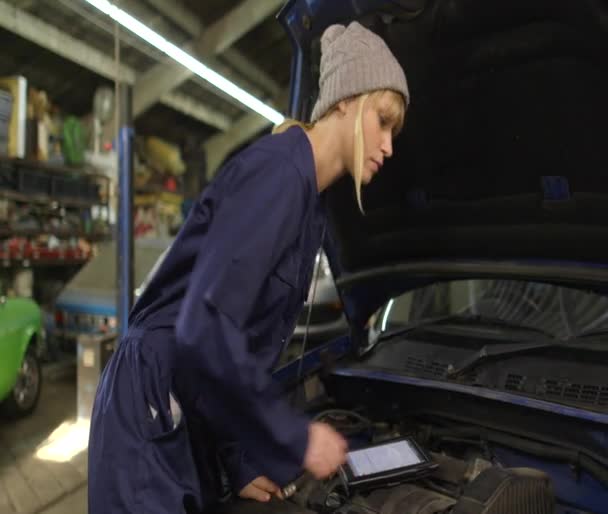 Portrait of a female mechanic using a digital tablet while doing routine checkup — Stock Video