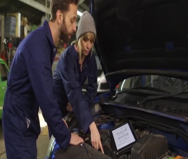 Mechanik kobiece i stażysta podczas warsztatów przed samochód — Wideo stockowe