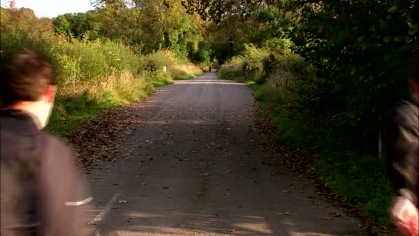 Dos hombres pasan por el camino del campo. — Vídeos de Stock