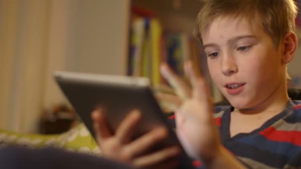 Jonge jongen spelen van computerspelletjes op een touchscreen tablet. Dolly schot. — Stockvideo
