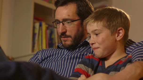 Pai e filho desfrutando de um filme em um tablet. Dolly Shot . — Vídeo de Stock