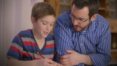 Babası küçük oğlu ev ödevlerinde yardımcı olur